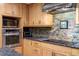 This updated kitchen has stainless steel appliances, granite countertops, a tile backsplash, and natural wood cabinets at 109 Loch Haven Ln, Cary, NC 27518