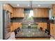 Modern kitchen features granite countertops, a center island, stainless steel appliances, and a brick backsplash at 109 Loch Haven Ln, Cary, NC 27518
