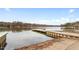 Lake view with a dock, trees, and serene water under a bright sky at 109 Loch Haven Ln, Cary, NC 27518