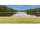 Scenic view of a calm pond reflecting the sky, framed by trees and green grass at 109 Loch Haven Ln, Cary, NC 27518