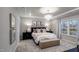 Charming main bedroom with a tray ceiling, a statement chandelier, and a large window overlooking the front yard at 1111 Cosmic Dr, Durham, NC 27703