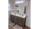 Bathroom with double vanity, decorative rugs, framed mirror, and neutral color palette at 1116 Powder, Fuquay Varina, NC 27526