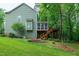 Exterior view of a green home with a screened porch and deck in a grassy backyard at 112 Hidden Bluff Ln, Cary, NC 27513