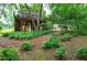 Green backyard with lush ground cover and mulched path leading to the house with deck at 112 Hidden Bluff Ln, Cary, NC 27513