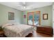 Cozy bedroom features a ceiling fan, hardwood floors, and a window overlooking the yard at 112 Hidden Bluff Ln, Cary, NC 27513