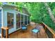 Enclosed porch and deck features an exterior chair with blue cushions and overlooks a peaceful tree lined property at 112 Hidden Bluff Ln, Cary, NC 27513