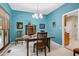 Cozy dining room with blue walls, wood furniture, neutral carpet, and bright chandelier lighting at 112 Hidden Bluff Ln, Cary, NC 27513