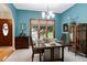 Bright dining room featuring craftsman style table, light fixture and teal walls at 112 Hidden Bluff Ln, Cary, NC 27513