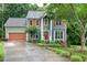 Charming two-story home featuring a well-manicured lawn, a brown garage door, and orange window shutters at 112 Hidden Bluff Ln, Cary, NC 27513
