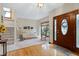Foyer with a decorative wood front door, leading into the living room with a staircase to the second floor at 112 Hidden Bluff Ln, Cary, NC 27513