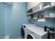 Functional laundry room with modern washer and dryer, lots of storage shelves, and ample counter space at 112 Hidden Bluff Ln, Cary, NC 27513