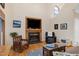 Cozy living room featuring a fireplace with built-in TV, comfortable seating, and warm hardwood floors at 112 Hidden Bluff Ln, Cary, NC 27513