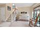 A cozy living room with carpet flooring, a staircase, a white sofa, and natural light from the windows at 112 Hidden Bluff Ln, Cary, NC 27513