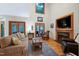 Bright living room features a fireplace with built-in TV, plenty of seating, and ample natural light at 112 Hidden Bluff Ln, Cary, NC 27513