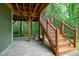 Under-deck patio offers an outdoor living area with stone pavers and wood staircase at 112 Hidden Bluff Ln, Cary, NC 27513