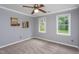 Comfortable bedroom featuring neutral carpet, a ceiling fan, and two bright windows at 11816 Stannary Pl, Raleigh, NC 27613