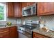 Cozy kitchen features stainless steel appliances, granite countertops, and ample wood cabinetry at 11816 Stannary Pl, Raleigh, NC 27613