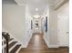 Elegant hallway with wood flooring, white wainscoting, and a staircase, leading to the front door at 1205 Cosmic Dr, Durham, NC 27703