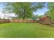 Spacious backyard featuring a privacy fence, mature trees and outbuilding at 12449 W Pamlico St, Middlesex, NC 27557