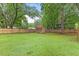 Spacious backyard featuring a privacy fence, mature trees and outbuilding at 12449 W Pamlico St, Middlesex, NC 27557