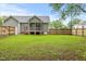 Backyard featuring green grass, a privacy fence, and view of the screened-in back porch at 12449 W Pamlico St, Middlesex, NC 27557