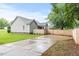 Spacious driveway with a wooden fence, leading to a gray home with a green lawn at 12449 W Pamlico St, Middlesex, NC 27557