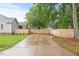 View of the spacious driveway leading to a gray single-story home with a wooden fence at 12449 W Pamlico St, Middlesex, NC 27557