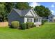 Side view of home showcasing well-maintained landscaping, gray siding, black shutters, and lovely lawn at 12449 W Pamlico St, Middlesex, NC 27557