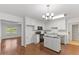 Bright kitchen featuring white cabinets, black appliances, and a center island on wood floors at 12449 W Pamlico St, Middlesex, NC 27557