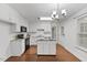 Well-lit kitchen with white cabinets, island, and stainless steel appliances at 12449 W Pamlico St, Middlesex, NC 27557