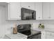 Close up of black oven and microwave with white subway tile backsplash and light marbled countertops at 12449 W Pamlico St, Middlesex, NC 27557