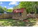 Charming backyard outbuilding with a red metal roof and wooden exterior at 12449 W Pamlico St, Middlesex, NC 27557