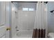 Bright white bathroom features a shower/tub combo with white and grey shower curtain at 13121 Sargas St, Raleigh, NC 27614