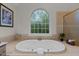 Bright bathroom featuring a soaking tub, large window, and tiled surround at 13121 Sargas St, Raleigh, NC 27614
