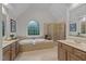 Relaxing bathroom with a soaking tub, separate shower, double vanity, and large arched window at 13121 Sargas St, Raleigh, NC 27614