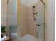 Tile-walled shower stall with adjustable shower head, small built-in shelf, and glass door at 13121 Sargas St, Raleigh, NC 27614