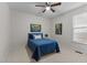 Cozy bedroom with a blue bed, ceiling fan, and natural light from the window at 13121 Sargas St, Raleigh, NC 27614