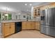 Modern kitchen with stainless steel refrigerator, light wood cabinets, and a black dishwasher at 13121 Sargas St, Raleigh, NC 27614
