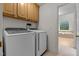 Functional laundry room featuring modern appliances and cabinets, with an adjoining bathroom with a jetted tub at 13121 Sargas St, Raleigh, NC 27614