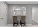 Basement wet bar with seating and a view into the utility room at 13121 Sargas St, Raleigh, NC 27614