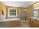 This bathroom features a tub and a separate glass shower, complemented by a large window that provides ample natural light at 1420 Norwood Crest Ct, Raleigh, NC 27614