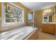 This bathroom offers a large soaking tub under the window, alongside a separate shower, and a beautiful vanity at 1420 Norwood Crest Ct, Raleigh, NC 27614