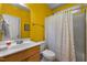 Bathroom with yellow walls and a shower with a polka dot curtain at 1420 Norwood Crest Ct, Raleigh, NC 27614