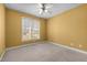 Bedroom with yellow walls, window, and carpeted floor at 1420 Norwood Crest Ct, Raleigh, NC 27614