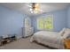 This bedroom with blue walls has a well lit window and a ceiling fan above, which complements the classic decor at 1420 Norwood Crest Ct, Raleigh, NC 27614