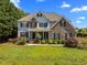 Two-story home with a stone facade, manicured lawn, and mature landscaping at 1420 Norwood Crest Ct, Raleigh, NC 27614
