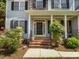 Inviting front porch with black front door, brick steps and lush landscaping at 1420 Norwood Crest Ct, Raleigh, NC 27614
