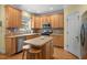 Bright kitchen features wood cabinets, island with seating, and stainless steel appliances at 1420 Norwood Crest Ct, Raleigh, NC 27614