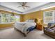 Large main bedroom features tray ceilings, three windows, ceiling fan, and carpet at 1420 Norwood Crest Ct, Raleigh, NC 27614