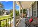 Relaxing front porch with a wooden swing and black iron railing and white columns at 1420 Norwood Crest Ct, Raleigh, NC 27614